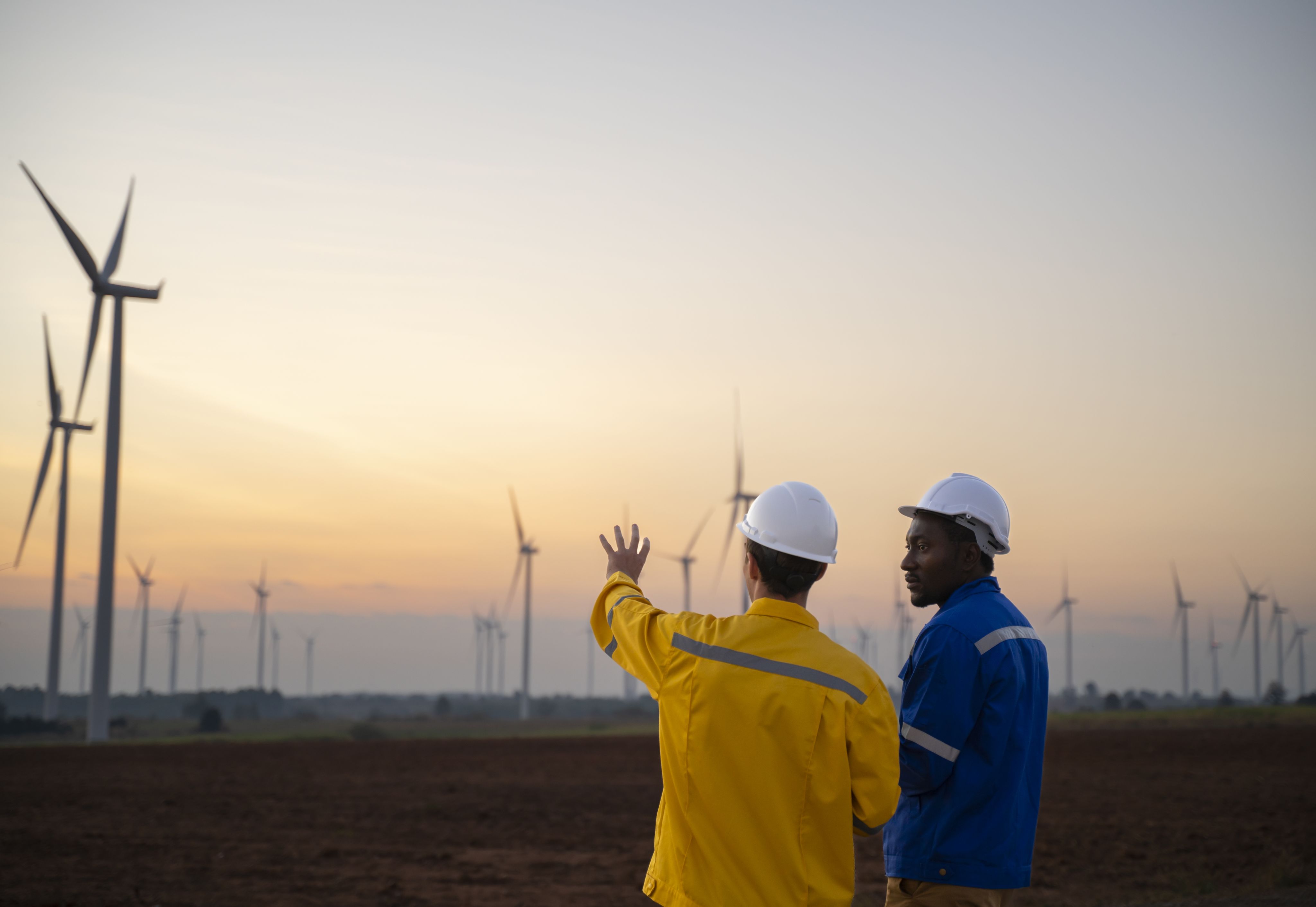 two men having a discussion in front of windmills 