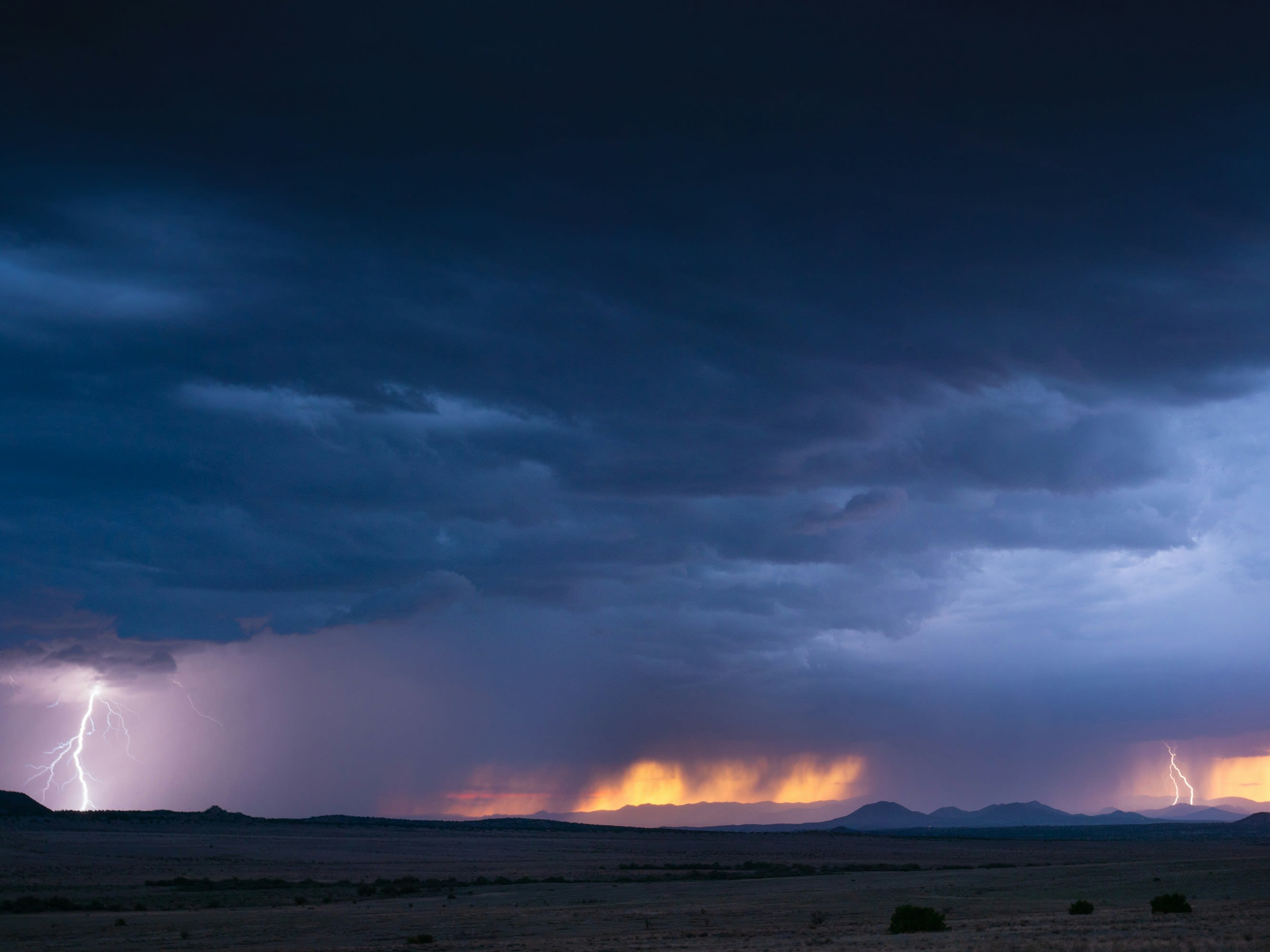 a lightning storm is seen in the distance