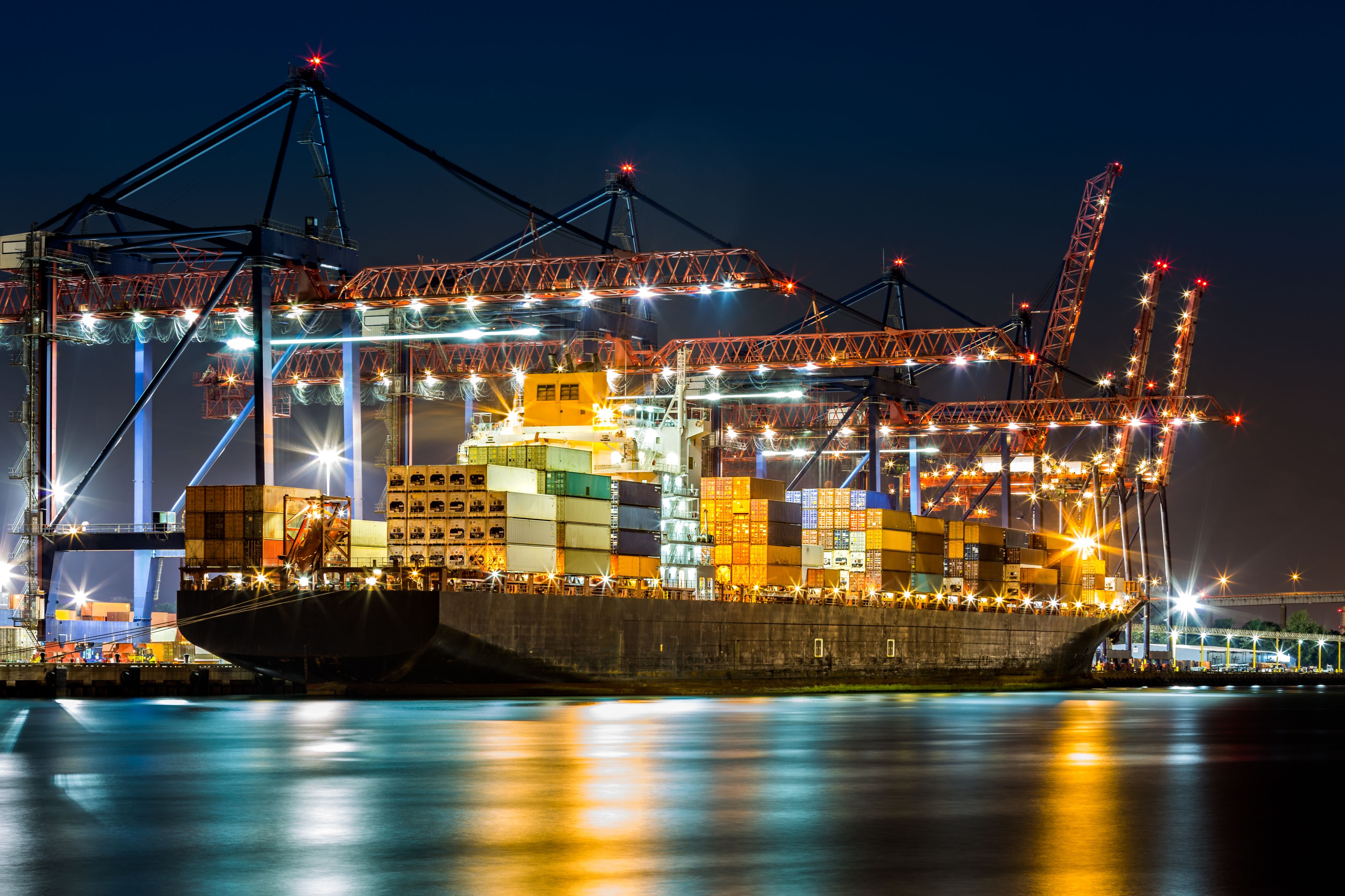 a tug boat in the water next to a large cargo ship